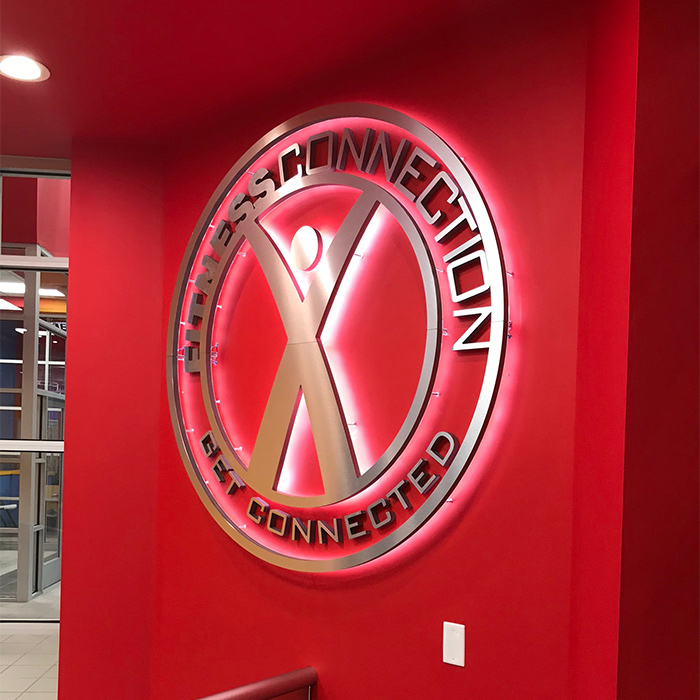 illuminated gym sign installed at building red wall dallas tx